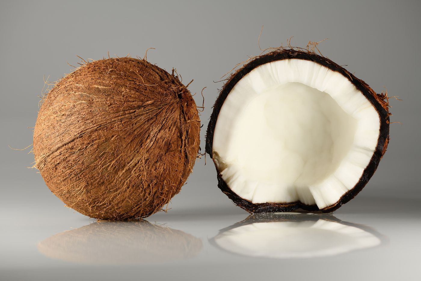 Coconuts, one cracked open to show the water